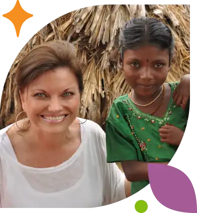 Jan Rees-Jones sits smiling with a young girl in a green dress.